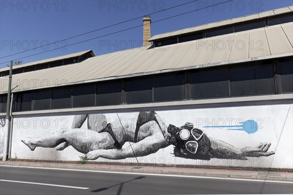 Reclining woman in bikini with diving mask, surreal mural in black and white by Greek street artist
