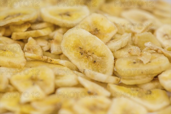 Fresh made Dried Banana Chips on an old and rustic wooden table, selective focus, close-up shot