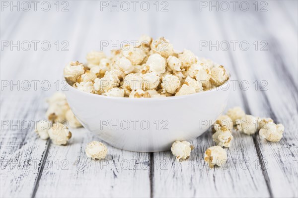 Popcorn as high detailed close-up shot on a vintage wooden table, selective focus