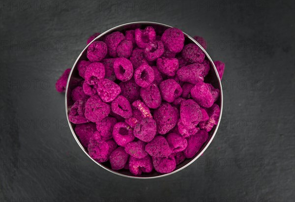 Dried Raspberries on a vintage slate slab as detailed close-up shot, selective focus