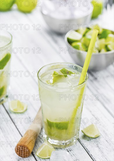 Vintage wooden table with Caipirinha (selective focus, close-up shot)