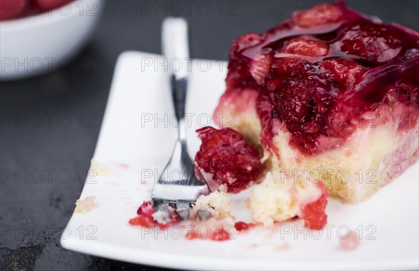 Fresh made Raspberry Cake on a rustic slate slab (close-up shot, selective focus)