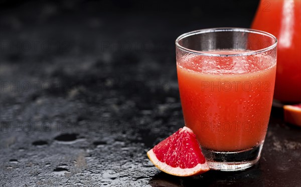 Slate slab with freshly squeezed Grapefruit Juice (selective focus, close-up shot)