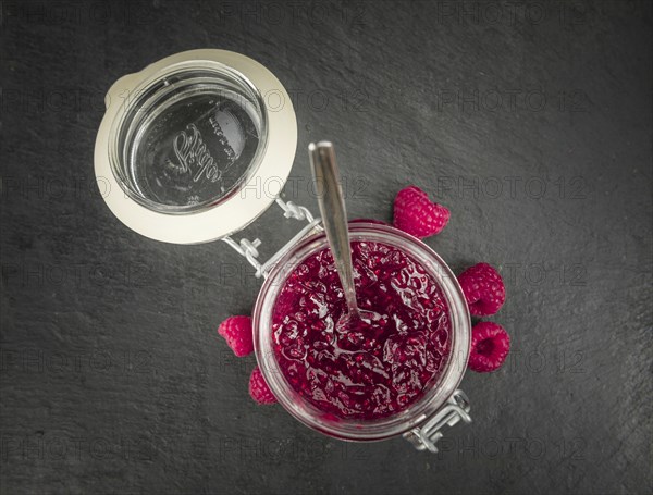 Portion of Raspberry Jam on a rustic slate slab, selective focus, close-up shot