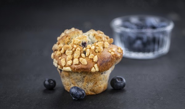 Portion of healthy Blueberry Muffins on a slate slab (selective focus)