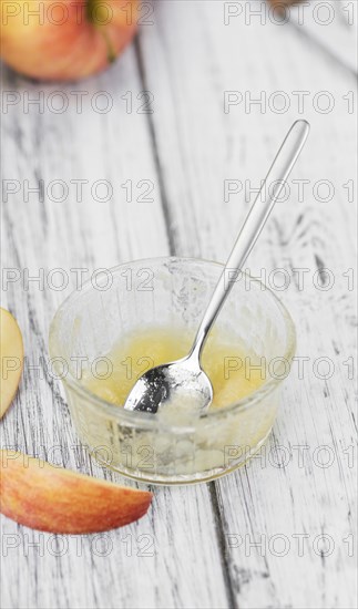 Homemade Applesauce (selective focus, close-up shot) on vintage background with some fresh fruits