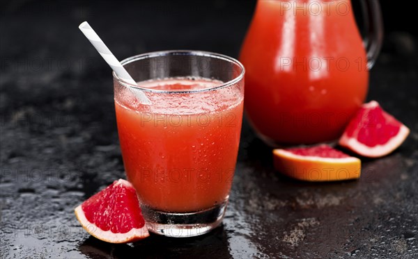 Some freshly squeezed Grapefruit Juice on a vintage background (close-up shot, selective focus)