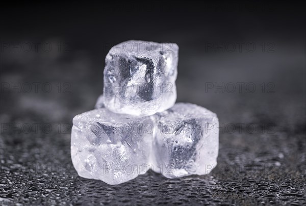 Some melting Ice cubes on a vintage slate slab (selective focus)