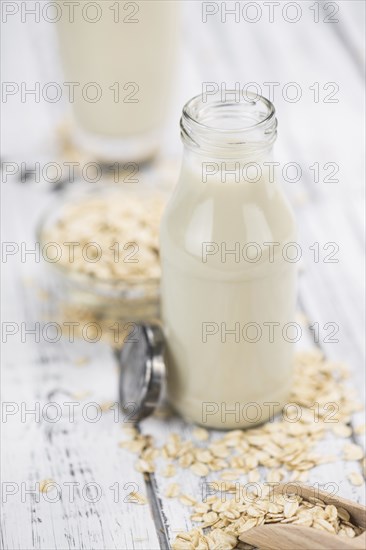 Wooden table with Oat Milk (detailed close-up shot, selective focus)
