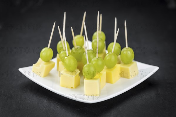 Cheese blocks with grapes as close-up shot (selective focus, partyfood)