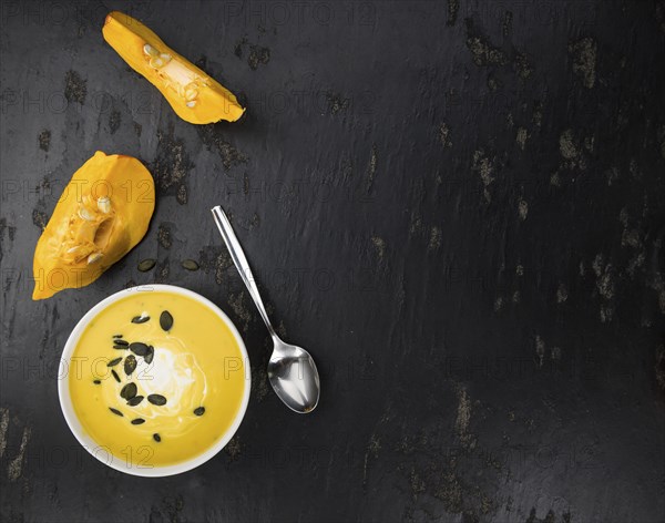 Fresh made Pumpkin Soup (close-up shot) on a vintage background (selective focus)