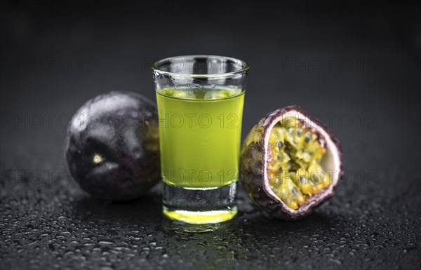 Passion Fruit Liqueur on a vintage looking slate slab (selective focus)