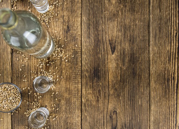 Vintage wooden table with Wheat Liqueur (selective focus, close-up shot)