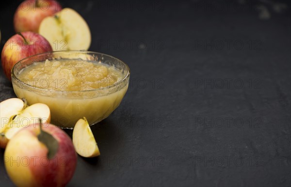 Homemade Applesauce (selective focus, close-up shot) on vintage background with some fresh fruits