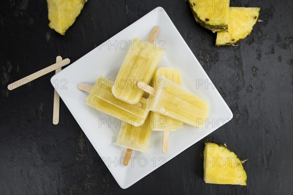 A rustic slate slab with homemade Popsicles (selective focus, close-up shot)