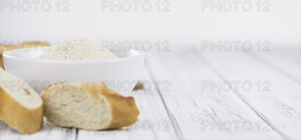 Old wooden table with fresh Breadcrumbs (close-up shot, selective focus)