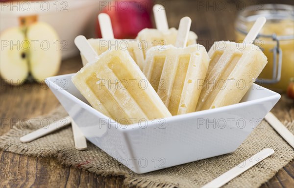 Apple Popsicles on an old wooden table (close-up shot, selective focus)
