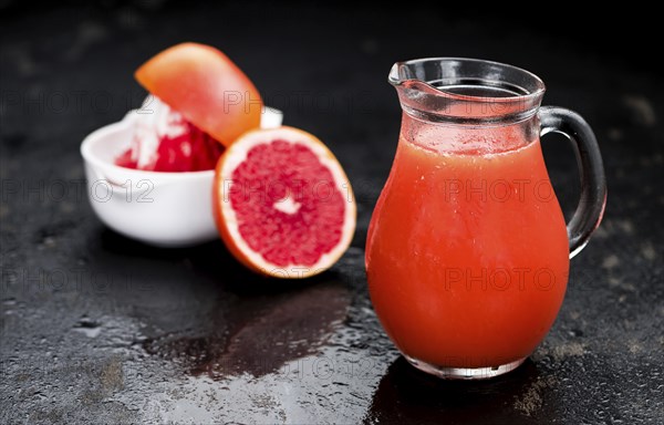 Slate slab with freshly squeezed Grapefruit Juice (selective focus, close-up shot)