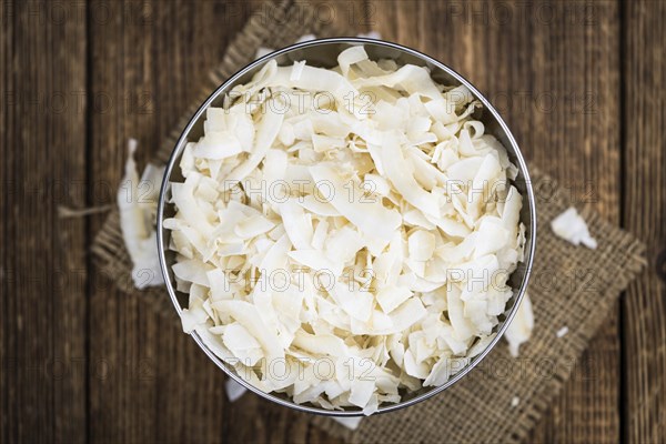 Coconut Chips (fresh) as detailed close-up shot, selective focus)