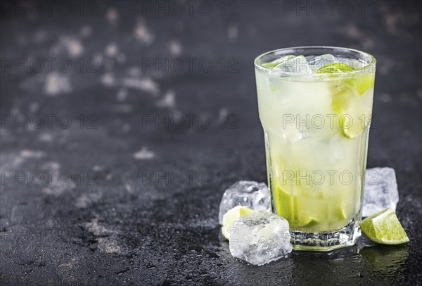 Fresh made Caipirinha with ingredients in the background