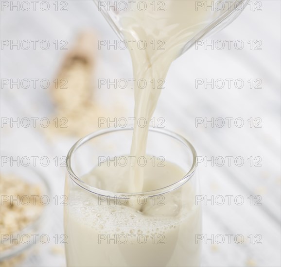 Wooden table with Oat Milk (detailed close-up shot, selective focus)