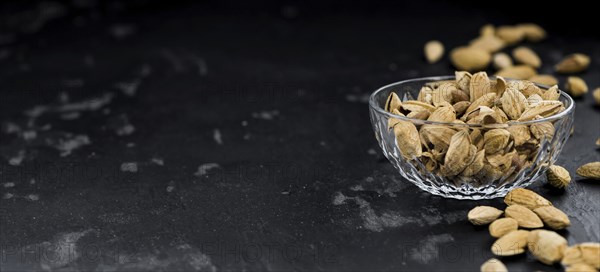 Almonds in shell (roasted and salted) on a vintage background (close-up shot)