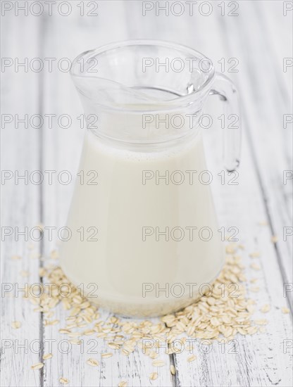Wooden table with Oat Milk (detailed close-up shot, selective focus)