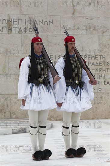 Two Evzones in traditional dress stand guard in front of the parliament building, Tomb of the