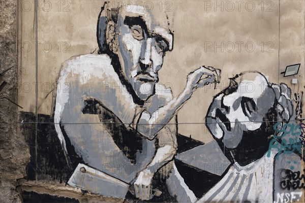 Figure with cleaver rips out man's tooth, graffiti in Exarchia, neighbourhood of students and