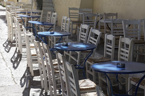 Row of blue tables and white chairs, taverna in the historic centre of Plaka, Athens, Greece,