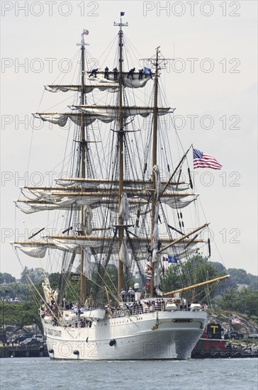 New London, Connecticut, USA, July 2012: Crew members high up in the rigging furl the sails on the