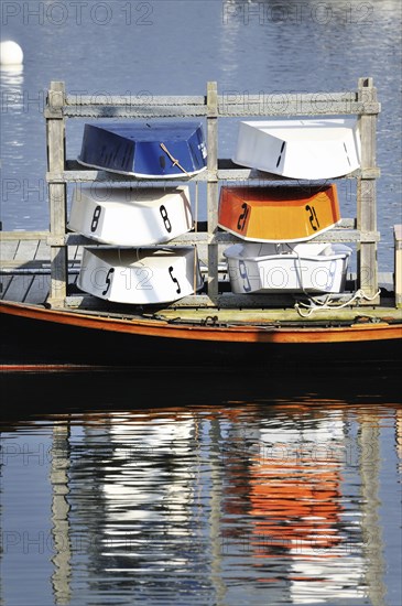 Six colorful blue, orange and white wooden dinghy sailboats stored for the evening, Rockland Maine