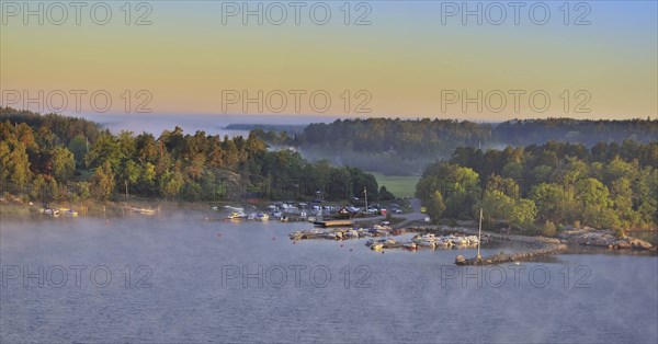 Sweeping panoramic view of boats moored amid the islands of the Stockholm Archipelago at dawn on a