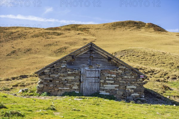 Stone mountain hut in a meadow under a clear blue sky, saas Fee, Alps, Switzerland, Europe
