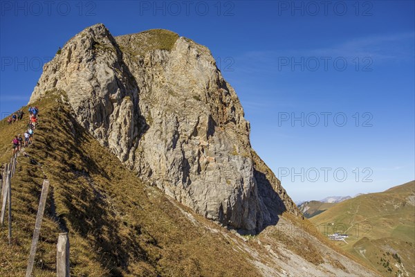 Steep cliff with hikers along a path under a clear sky, saas Fee, Alps, Switzerland, Europe
