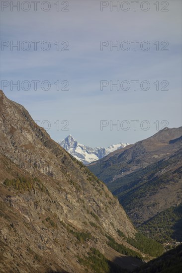 A narrow mountain gorge with snow-capped peaks in the background, Saas Fee, Switzerland, Europe