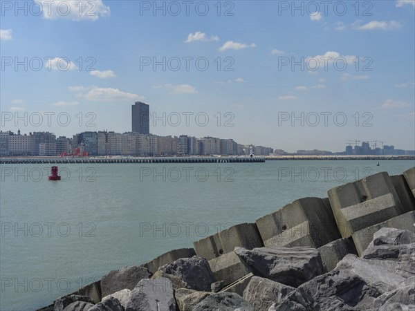 City on the coast with skyscrapers and breakwaters along the sea under a cloudy sky, oostende,