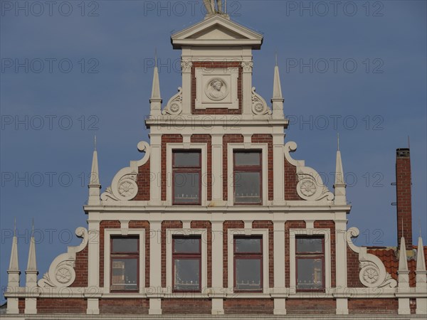 Decorative gable of a building with white decorations and windows, lüneburg, germany
