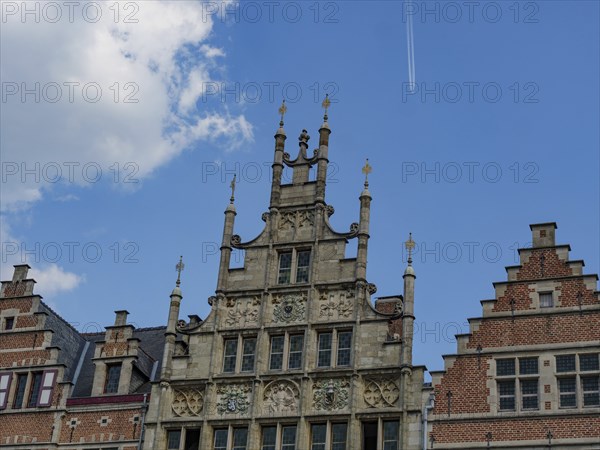 Close-up of richly decorated gables of an old building with a clear sky in the background, Ghent,