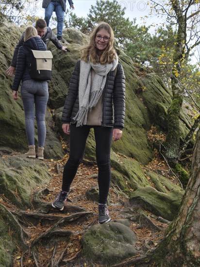 A woman enjoying autumn hiking over rocky terrain with friends, Tecklenburg, North