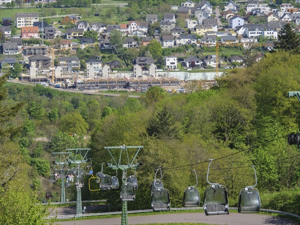 Cable car over a cityscape with hills and green trees under a blue sky, Saarburg, Germany, Europe