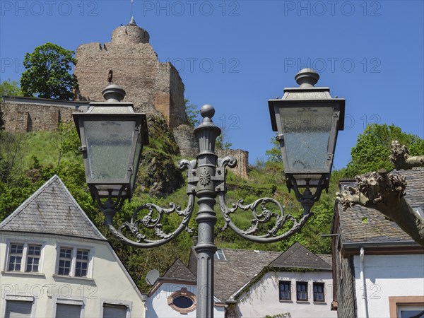 Two street lamps in front of a castle and other historical buildings in the village, Saarburg,