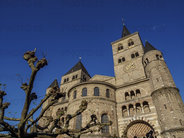 Stone church with several towers under a deep blue sky, Trier, Germany, Europe