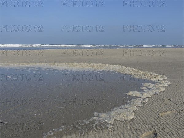 A wide, sandy shore with water accumulations and the sea in the background, juist, east frisia,