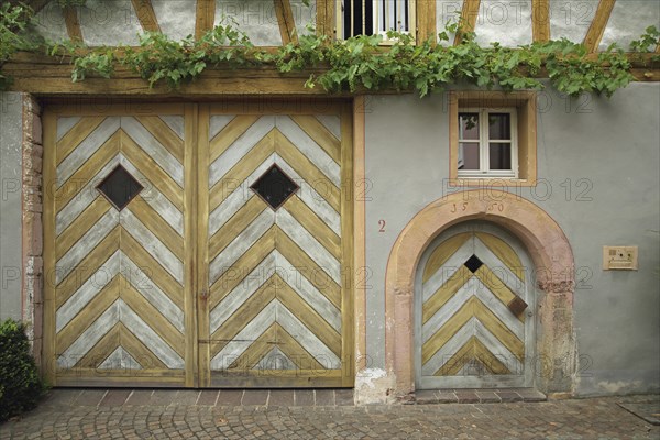 Yellow Tor tor and front door on half-timbered house built in 1550 with date and grapevine,