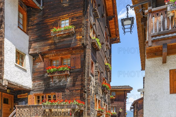 Old houses with flower boxes in front of windows and balconies in the historic village centre,