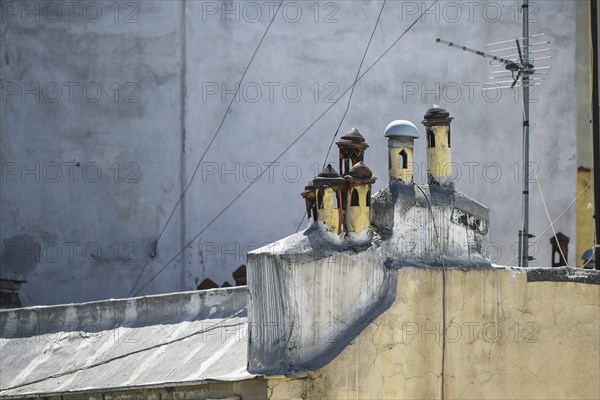 Small Mediterranean chimney pots with different caps looking like a miniature village on the