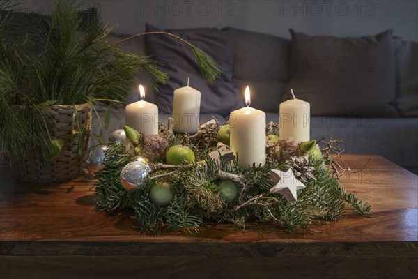 Second Advent, wreath with two burning white candles and Christmas decoration on a wooden table in