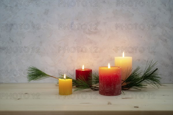 Four candles lit for the fourth Advent, pine branch as a simple, minimal decoration on a light