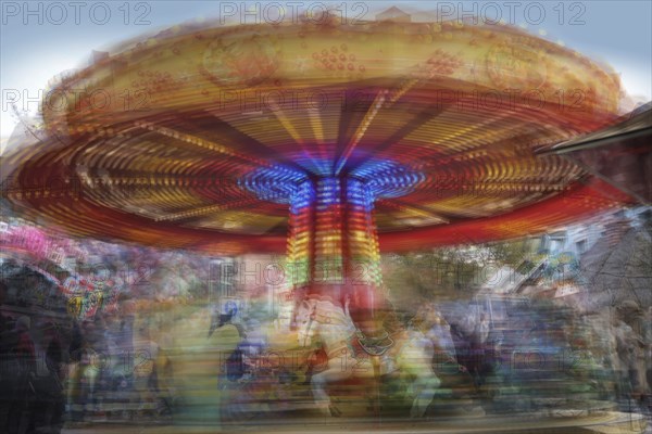Children carousel in motion at a Christmas fair, multiple long exposure, colorful abstract image,
